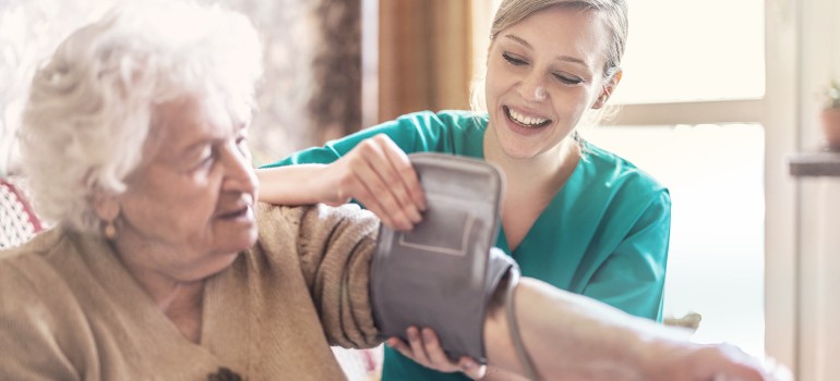 Fachkraft beim Blutdruckmessen