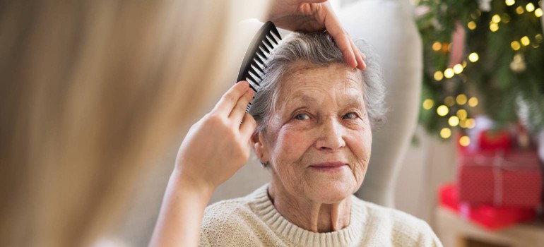 Eine ältere Dame bekommt die Haare gekämmt