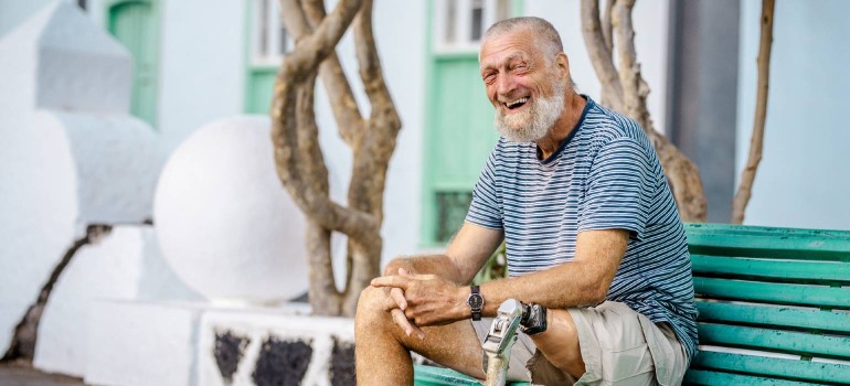 Ein Mann mit einer Beinprothese lächelt verschmitzt