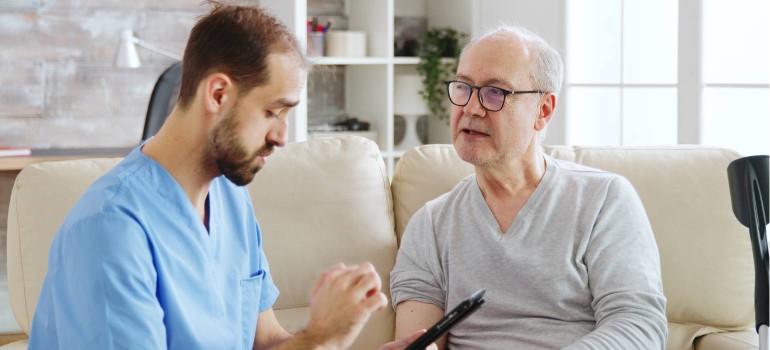 Ein Mann spricht mit einem Betreuer