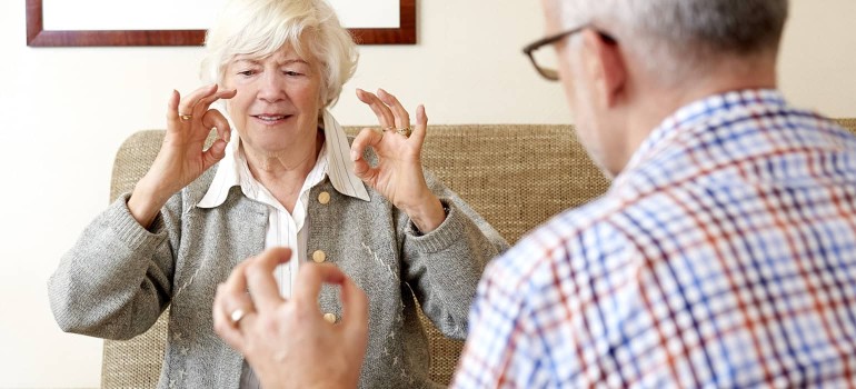 Ein Gutachter von Medicproof lässt sich Fingerbeweglichkeit zeigen