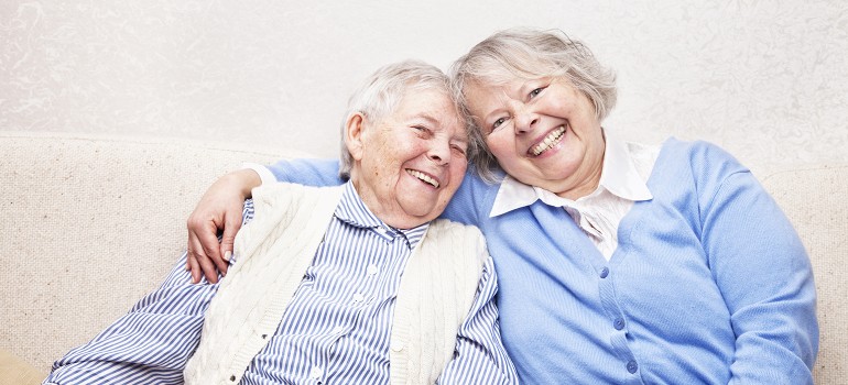 Zwei Frauen lachend auf dem Sofa