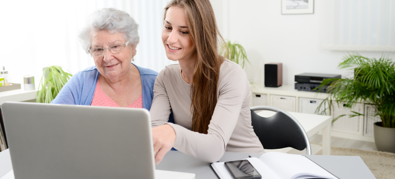Antrag auf Verhinderungspflege: Eine junge Frau hilft einer älteren Dame beim Antrag