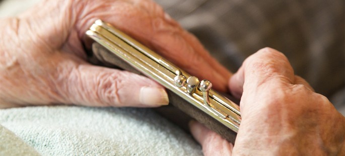 Zwei Hände einer älteren Person halten eine Geldbörse