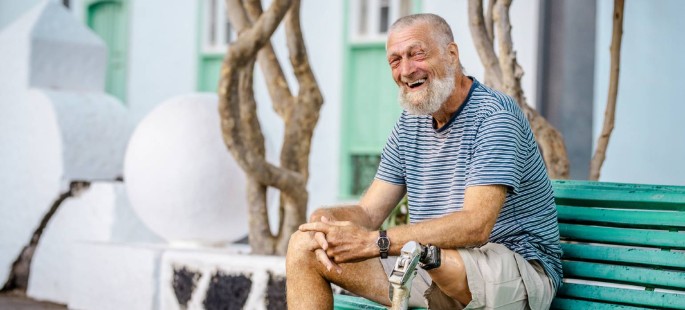 Ein Mann mit einer Beinprothese lächelt verschmitzt