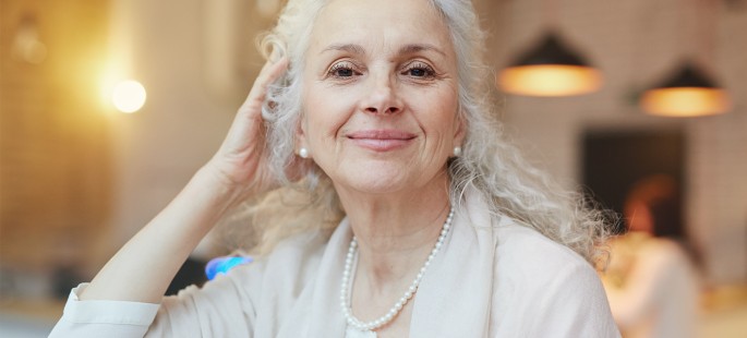 Eine vornehme ältere Dame in einer Seniorenresidenz lächelt