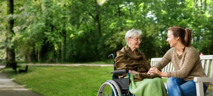 Alte und junge Frau auf einer Bank